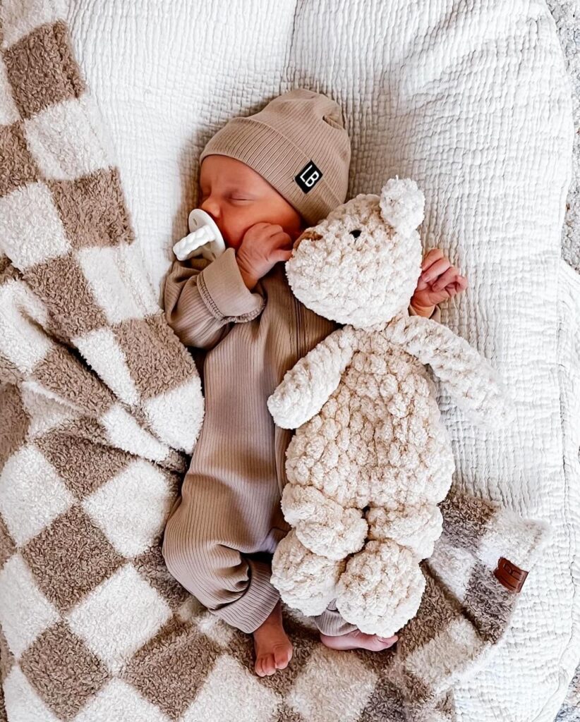 Slapende baby met snuggler voor een mijlpaalfoto.